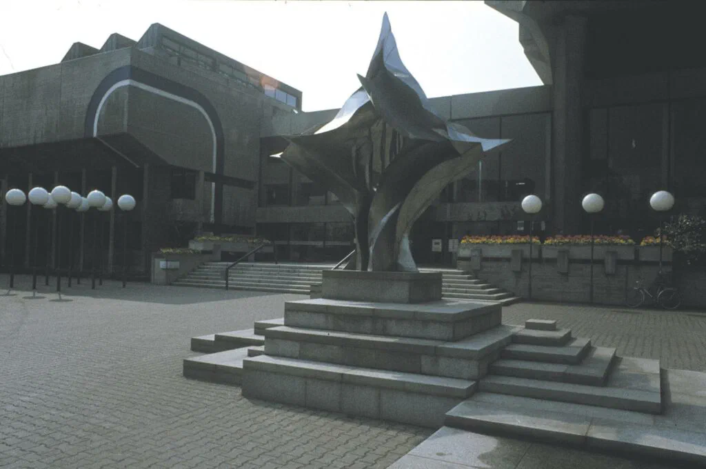Flamme, Ansicht vor Gebäude mit Kugellampen, Skulptur, Edelstahl