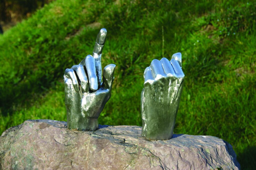 Minotaurus, Detail: zwei geschweißte Hände aus Edelstahl auf Stein