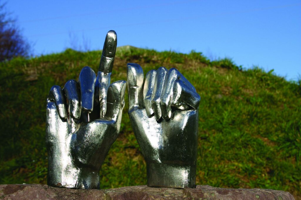 Minotaurus, Detail: zwei geschweißte Hände aus Edelstahl auf Stein