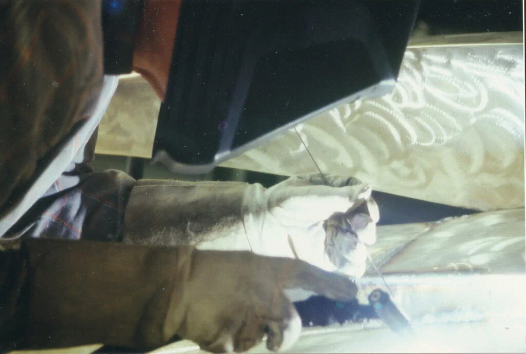 Sphinx, Werkstattfoto, Detail: geschweißte Stahlteile mit Schutzhandschuhen